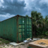 Shipping container in a Florida backyard with storm clouds overhead